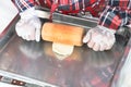 Step by step, baker prepares bread. baker slaps on dough. making bread, hand with rolling pin and flour