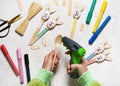 Step 8. Child used electric hot glue gun to attach rabbit ears to wooden spoon. Handmade gift or decor for easter with kids. Royalty Free Stock Photo