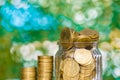 Step of coins stacks and gold coin money in the glass jar on tab Royalty Free Stock Photo