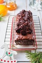 Step-by-step decoration of a carrot cake with chocolate glaze, ganache and candied fruits in a Christmas style on a light wooden Royalty Free Stock Photo