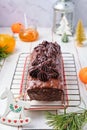 Step-by-step decoration of a carrot cake with chocolate glaze, ganache and candied fruits in a Christmas style on a light wooden Royalty Free Stock Photo