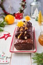 Step-by-step decoration of a carrot cake with chocolate glaze, ganache and candied fruits in a Christmas style on a light wooden Royalty Free Stock Photo