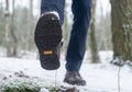 Step forward in winter forest. Male legs in boots walking