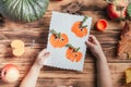 Step-by-step Halloween childrens tutorial pumpkin apple prints. Step 17: Child hands hold finished card, top view Royalty Free Stock Photo