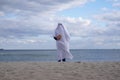 Ghost at seashore holding pumpkin on halloween