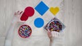Step-by-step instruction for thermo mosaics: step 2.Pair of kid`s hands,forms with pins,container of colorful beads Royalty Free Stock Photo