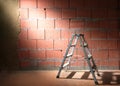 Step ladder in front of a brick wall from Porotherm style blocks partly plastered with clay in a construction site of a new