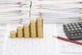 Step pile of gold coins with pencil and calculator Royalty Free Stock Photo