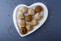 Step by step recipe. Cooking vegetarian energy balls. Step 2 Cooked carrot sweets with nuts, coconut flakes and raisins in heart Royalty Free Stock Photo