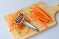 Step by step cooking. Pealed carrots on a wooden cutting board on a grey background.