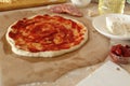 Step-by-step instructions for cooking pizza. Step 1. Roll the dough onto the dough and spread the tomato sauce. Dough with red Royalty Free Stock Photo