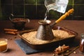 Step by step preparation of Turkish coffee on the sand. Step two, pouring cold water into the cezve Royalty Free Stock Photo