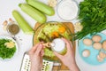 Step-by-step recipe to cook pancakes of zucchini and greens on a light background. with the addition of eggs, flour, garlic,