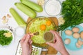 Step-by-step recipe to cook pancakes of zucchini and greens on a light background. with the addition of eggs, flour, garlic,