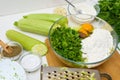 Step-by-step recipe to cook pancakes of zucchini and greens on a light background. with the addition of eggs, flour, garlic,
