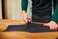 Step by step, Woman dressmaker hands cutting material with scissors on table