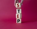 Step symbol. Concept word Step on wooden cubes. Businessman hand. Beautiful red background. Business and Step concept. Copy space Royalty Free Stock Photo