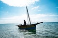 Life by the Sea: A Mozambican Fisherman in His Dhow Boat Royalty Free Stock Photo