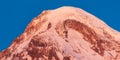 Georgia. Mount Kazbek Covered Snow In Winter Sunrise. Morning Dawn Colored Top Of Mountain In Pink-orange Colors Royalty Free Stock Photo