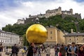 Stephan Balkenhol - Sphaera, a sculpture of a man on a golden sphere on KapitelplatzChaptr square in Salzburg, Austria