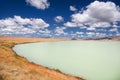 Steppe shore of a milky turquoise glacier lake with dry grass