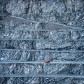Stepped wall of diabase stone quarry with red drilling rig Royalty Free Stock Photo