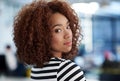 Stepping into the corporate world. Beautiful young woman looking over her shoulder at you with office space in the Royalty Free Stock Photo