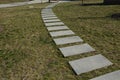 Stepping path of concrete tiles in the lawn straight row of concrete walkway in city park garden spring light white color tiles an Royalty Free Stock Photo