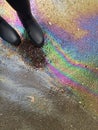 Stepping with rain boots on oil spill