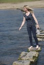 Stepping stones woman walking across river Royalty Free Stock Photo