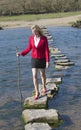 Stepping stones woman walking across river Royalty Free Stock Photo