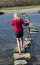 Stepping stones woman walking across river Royalty Free Stock Photo