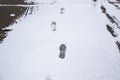 A steps against snow background. footprints on white snow background of boots. Human traces on snow