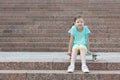 On the steps a girl sits on a skateboard