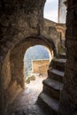 Steps inside the tower with access to a cliff in front of a mountain valley in the medieval town of Calcata in Italy