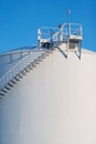 An industrial fuel storage tank and stairs.