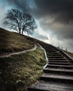 Steps leading up a countryside hill with storm clouds overhead Royalty Free Stock Photo