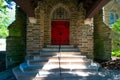 Steps Leading Up to a Red Door on a Cobblestone Church In a Covered Driveway Royalty Free Stock Photo