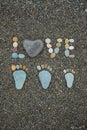 Steps of man, woman and kid made from stones on sandy beach. Royalty Free Stock Photo