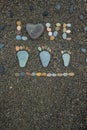 Steps of man, woman and kid made from stones on sandy beach. Royalty Free Stock Photo