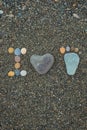 Steps of man, woman and kid made from stones on sandy beach. Royalty Free Stock Photo