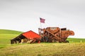 American flag flying from an antique combine wheat harvester Royalty Free Stock Photo