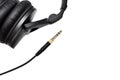 Stereo audio jack with cable with blurred headphones on white background with copy space for text.