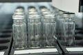 Sterile capsules for injection. Bottles on the bottling line of the pharmaceutical plant. Machine after checking sterile liquids. Royalty Free Stock Photo