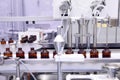 Sterile capsules for injection. Bottles on the bottling line of the pharmaceutical plant. Machine after checking sterile liquids. Royalty Free Stock Photo