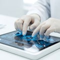 Sterile gloved hands operating a high-tech robotic interface control pad reflecting complex biological data patterns in a clean, p Royalty Free Stock Photo