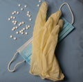 Sterile gloves and mask on a blue background. White pills Royalty Free Stock Photo