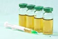 Sterile medical vials with medication solution, ampoules, and syringe on a light blue background Royalty Free Stock Photo