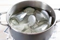 Sterilizing glass jars in a steel pan. Steaming bubbling wather Royalty Free Stock Photo