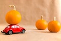 Sterlitamak, Russia - August 12, 2021: Red retro toy car delivering pumpkin on the roof. Autumn decor with pumpkins. Halloween